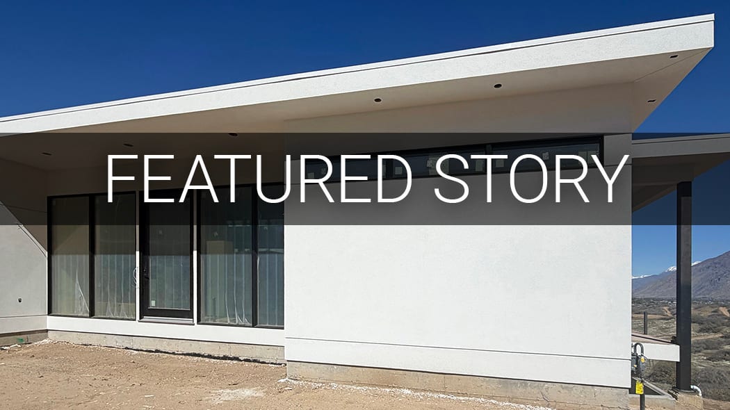 Modern white building with large windows and a flat roof under a blue sky, with "FEATURED STORY" overlaid.