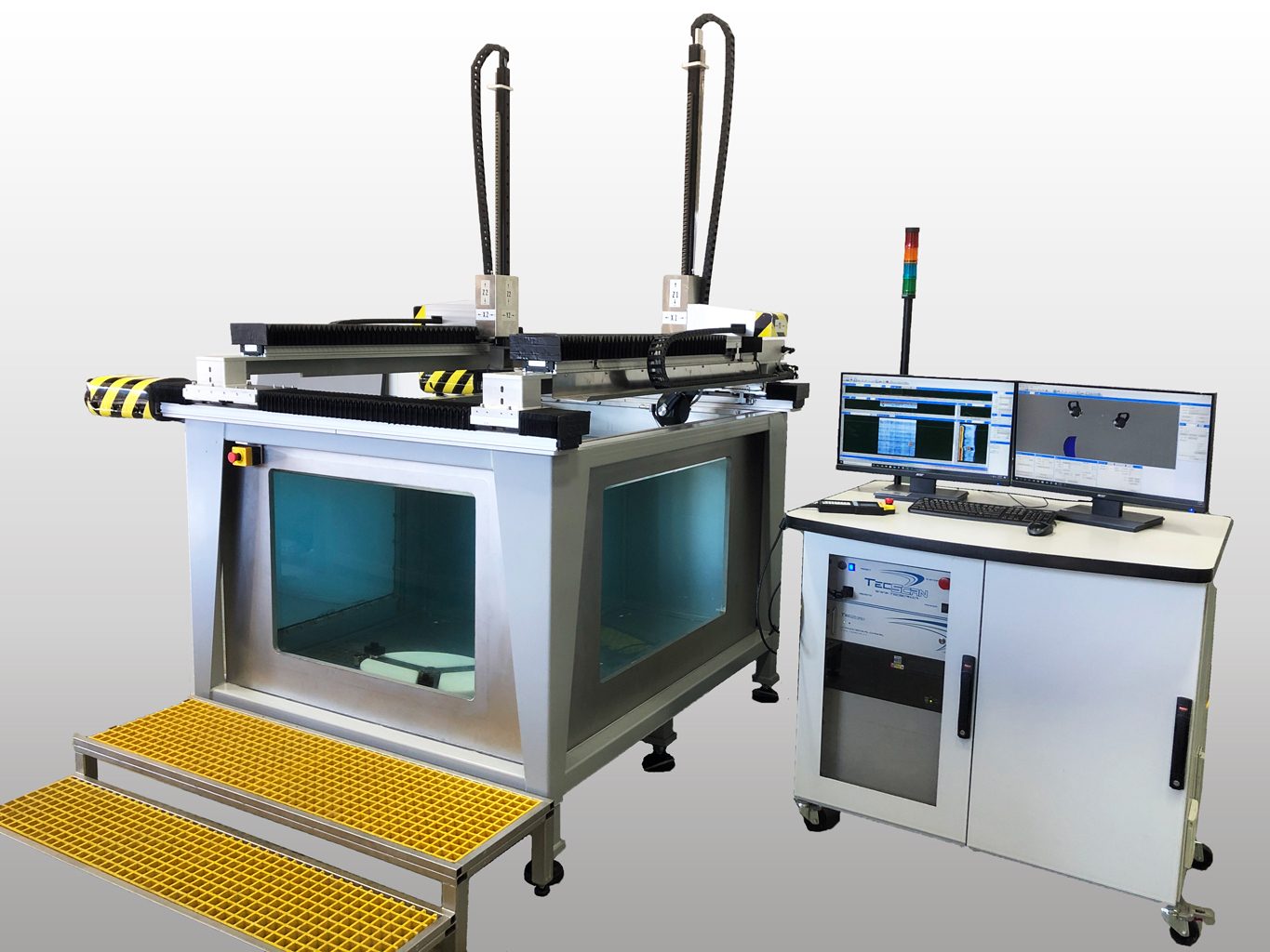 A TECScan industrial robotic inspection system with an overhead gantry, immersion tank, and dual-monitor control.