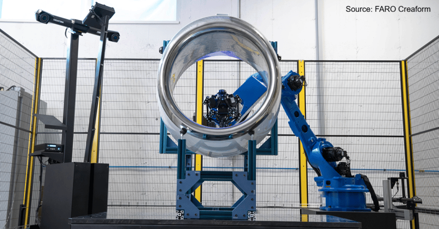 A robotic arm and 3D scanner inspect a large cylindrical part in an industrial setting.