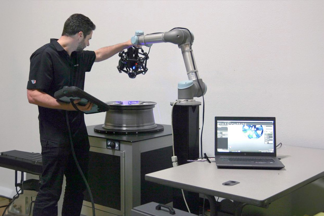 Worker using cobot to inspect part