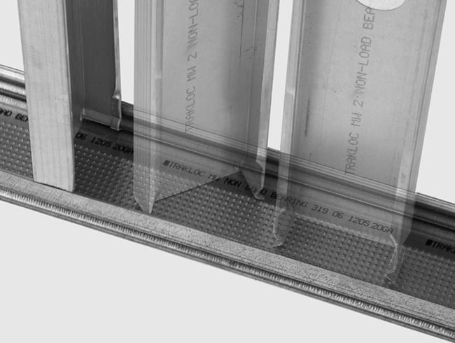 Metal studs being installed into a TRAKLOC non-load bearing track system.