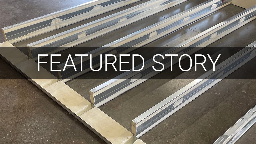 Long, gray building panels on a concrete floor, overlaid with "FEATURED STORY" text.