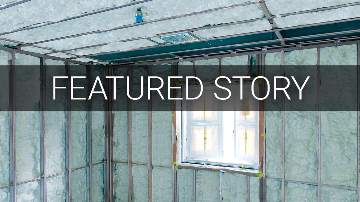 Room under construction with green insulation and metal studs. Text: "FEATURED STORY".