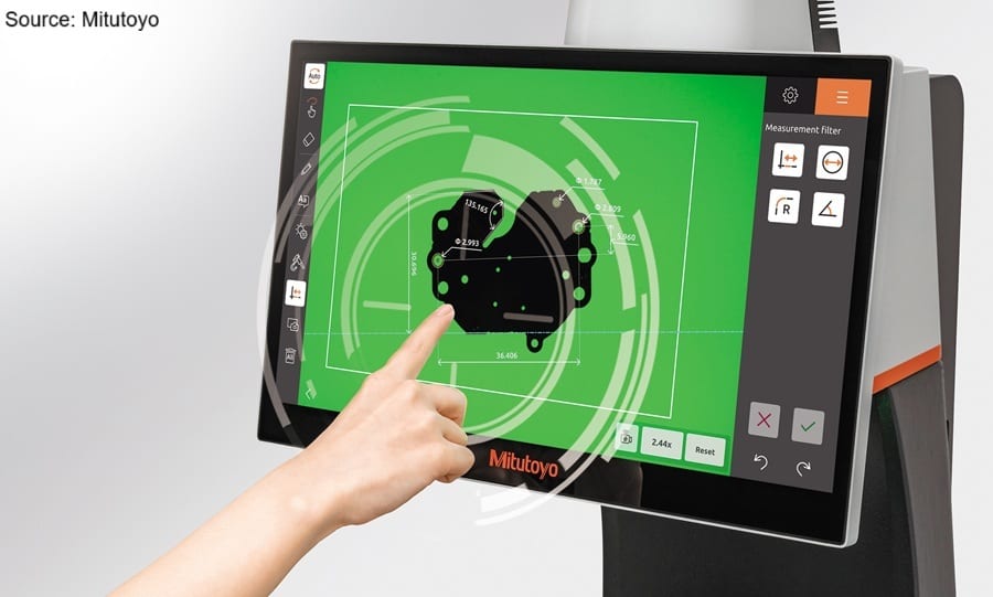 Hand touches a Mitutoyo touch screen displaying a technical drawing with measurements.