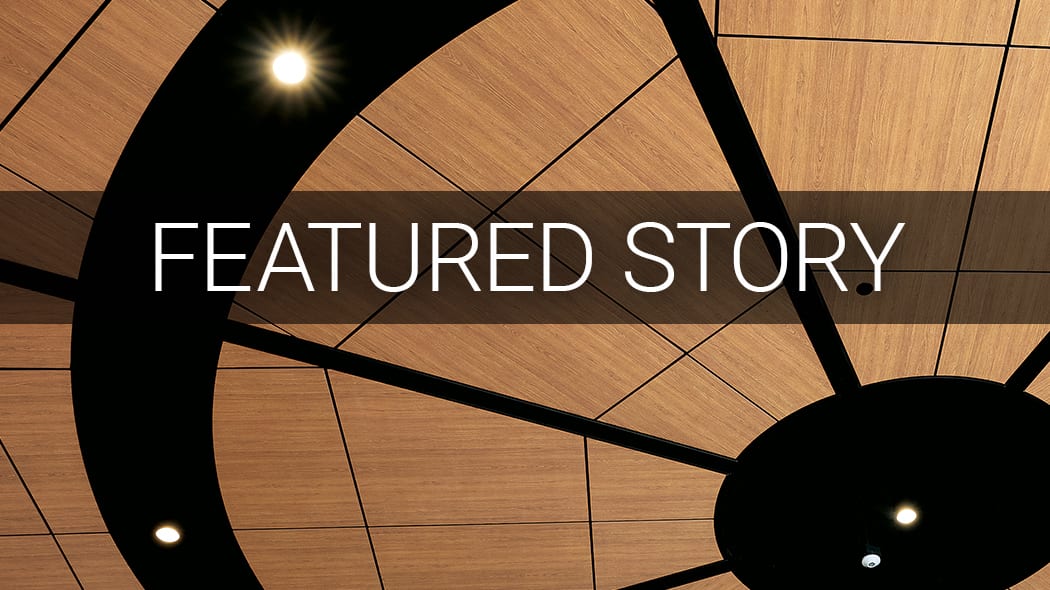 FEATURED STORY text on a wooden ceiling with black abstract design and lights.