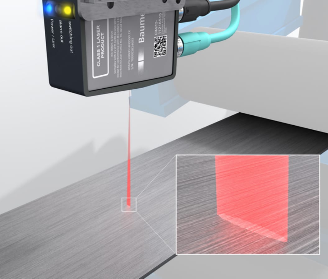 A laser sensor emitting a red beam onto a gray textured surface, with a magnified inset showing the laser's impact.