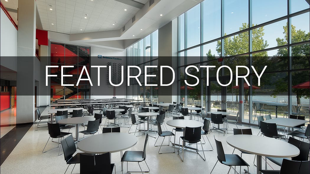 Modern cafeteria with large windows, tables, and 'FEATURED STORY' text overlay.
