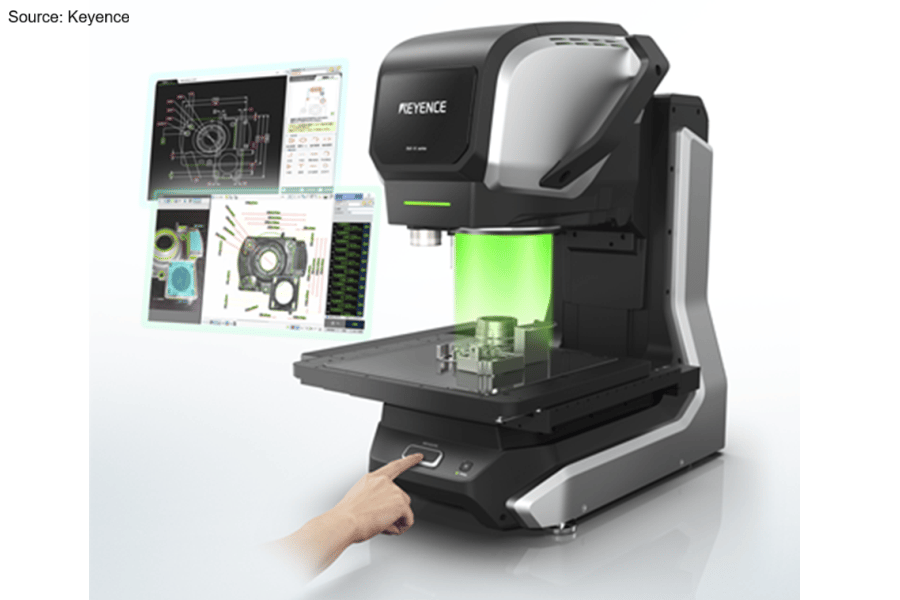 Keyence measurement system with green light, CAD displays, measuring a part. Hand on button.