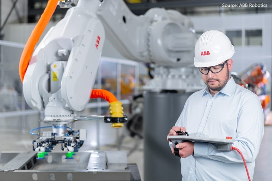 Man operating an ABB industrial robot.