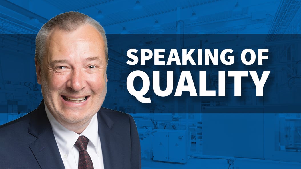Smiling man in suit, "SPEAKING OF QUALITY" text on blurred blue industrial background.