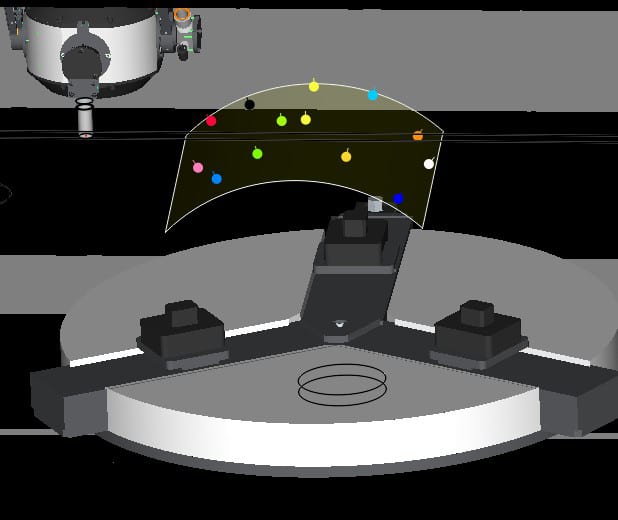 Robotic arm and circular chuck with jaws, under a curved screen displaying colorful spheres.