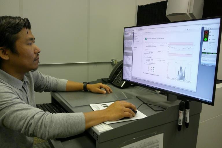 A man views process capability data on a computer screen.