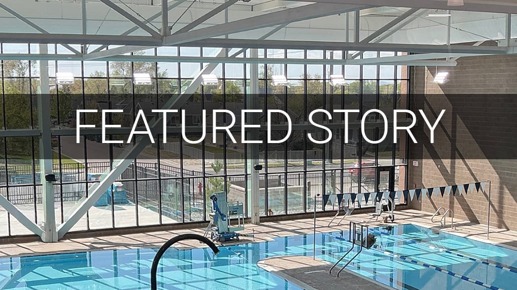 An indoor swimming pool with large windows showing an outdoor view, overlaid with "FEATURED STORY" text.