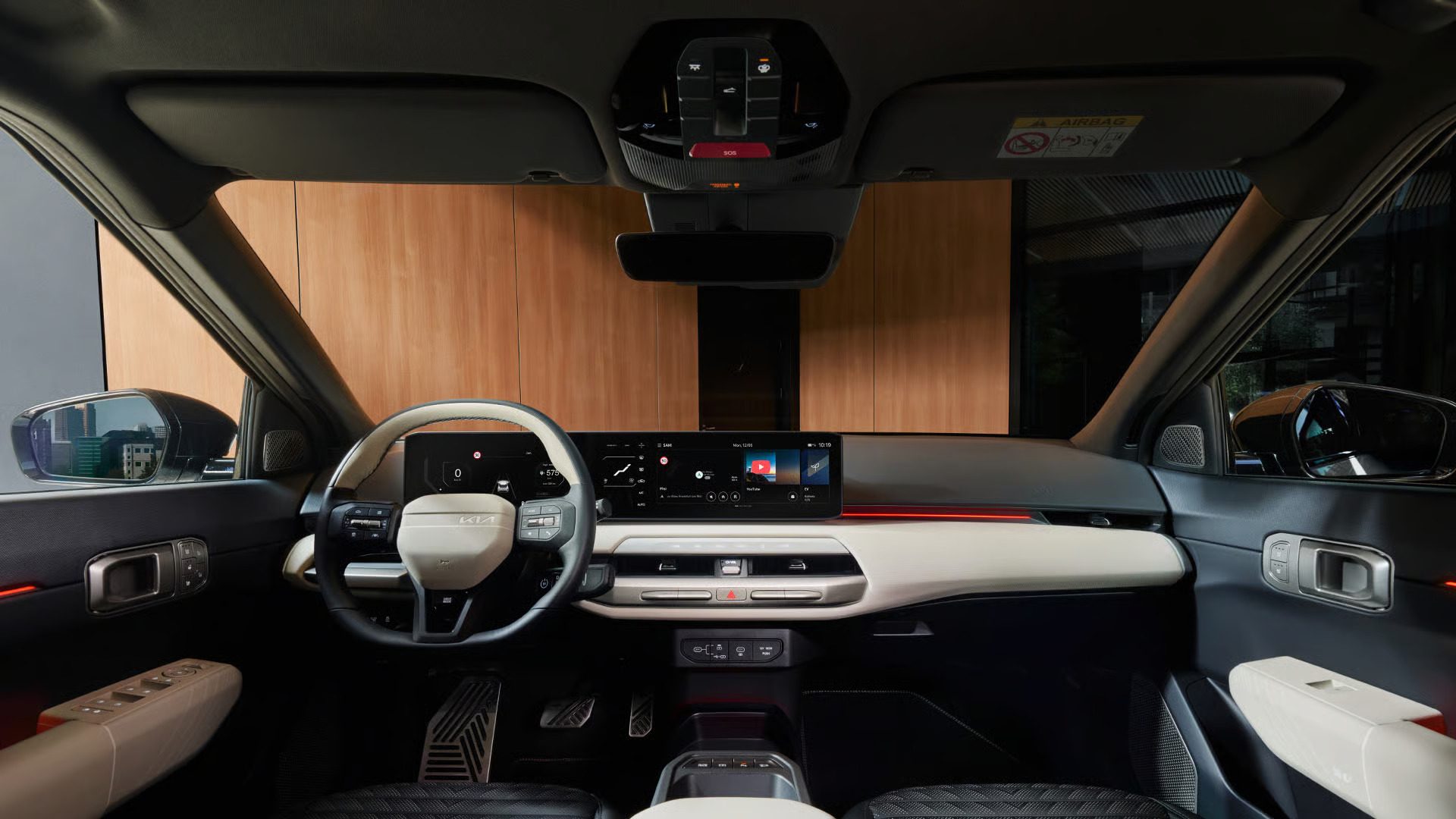 Modern car interior from driver's perspective, featuring a two-tone steering wheel, integrated digital screens, and a sleek dashboard.