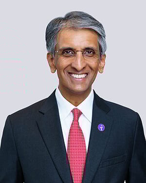 Smiling man in a suit and red tie.