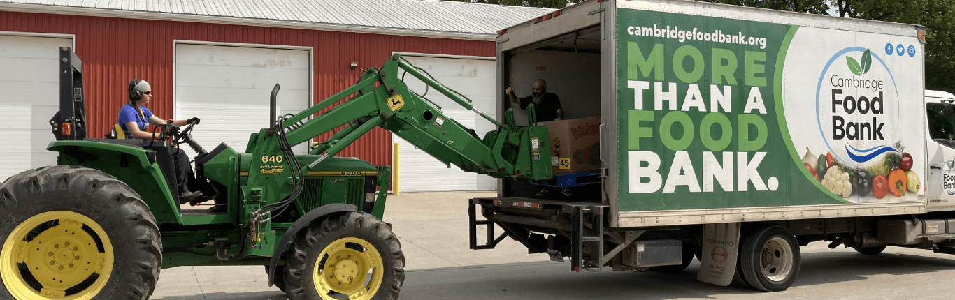 a tractor unloading boxes from a truck