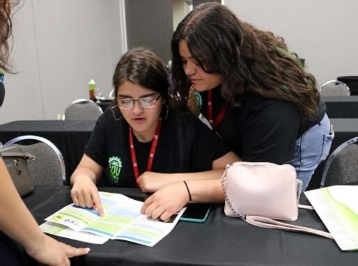 Students reading materials at a desk