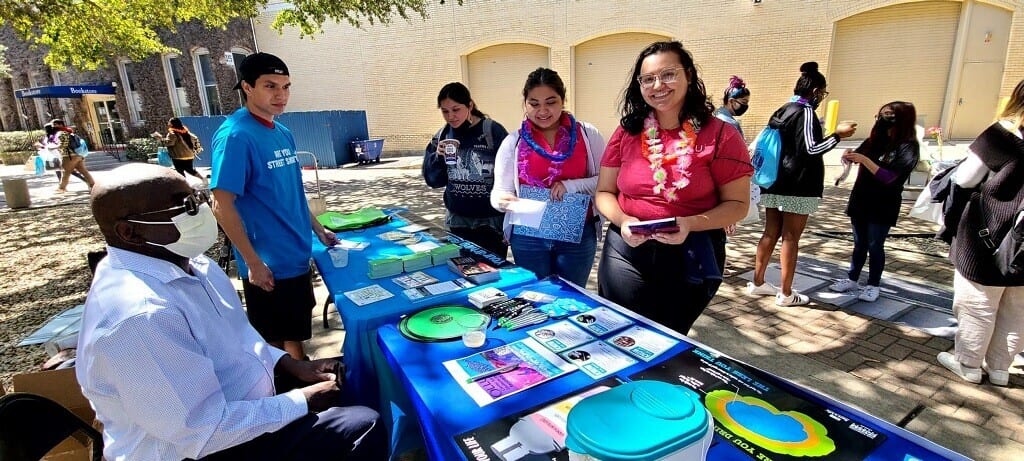 Students at spring break event table with impaired driving resources