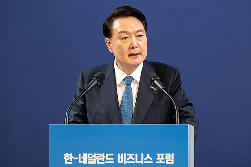 Dress shirt, Microphone, Outerwear, Tie, Coat, Gesture, Spokesperson, Collar