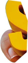 A human finger holds a bright yellow S-shaped object, possibly a puzzle piece or toy, against a dark background.