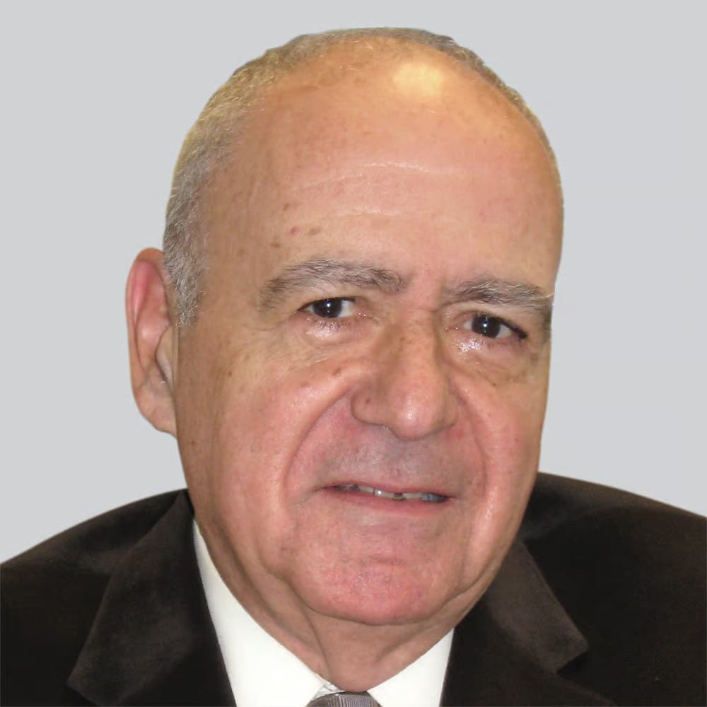 Headshot of a smiling older man in a suit.