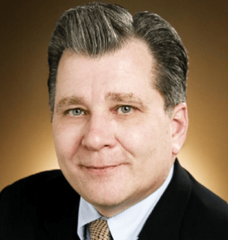 Smiling middle-aged man in a suit and tie headshot.