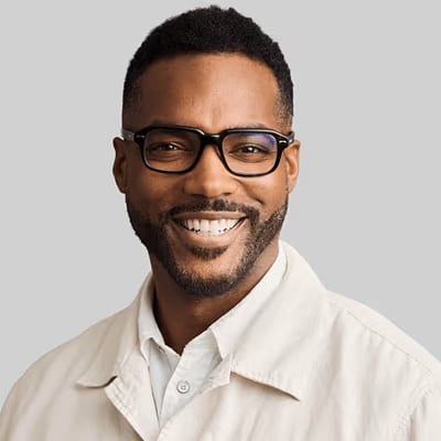 Smiling Black man with glasses and a beard.