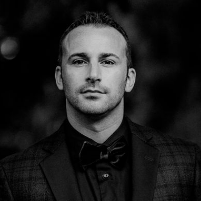 B&W portrait of a man in a bow tie, looking forward.