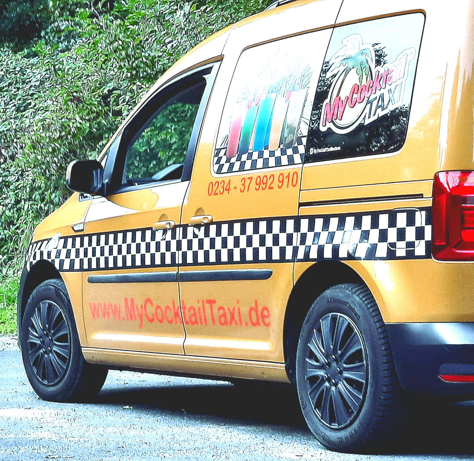 Yellow "My Cocktail Taxi" van with phone (0234-37 992 910), website, and checkered branding.