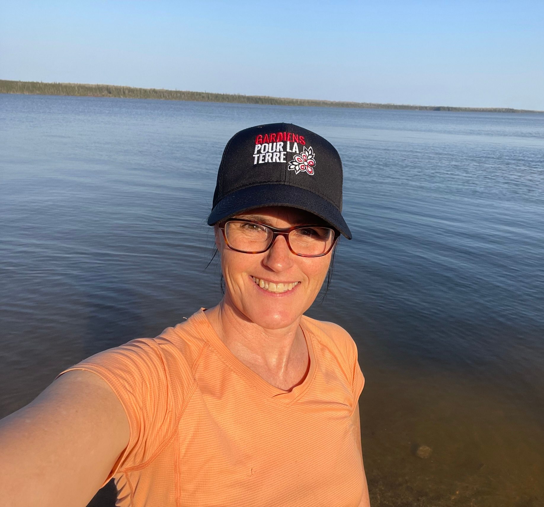Baseball cap, Water, Smile, Sky, Sleeve, Lake, Travel, Eyewear, Happy