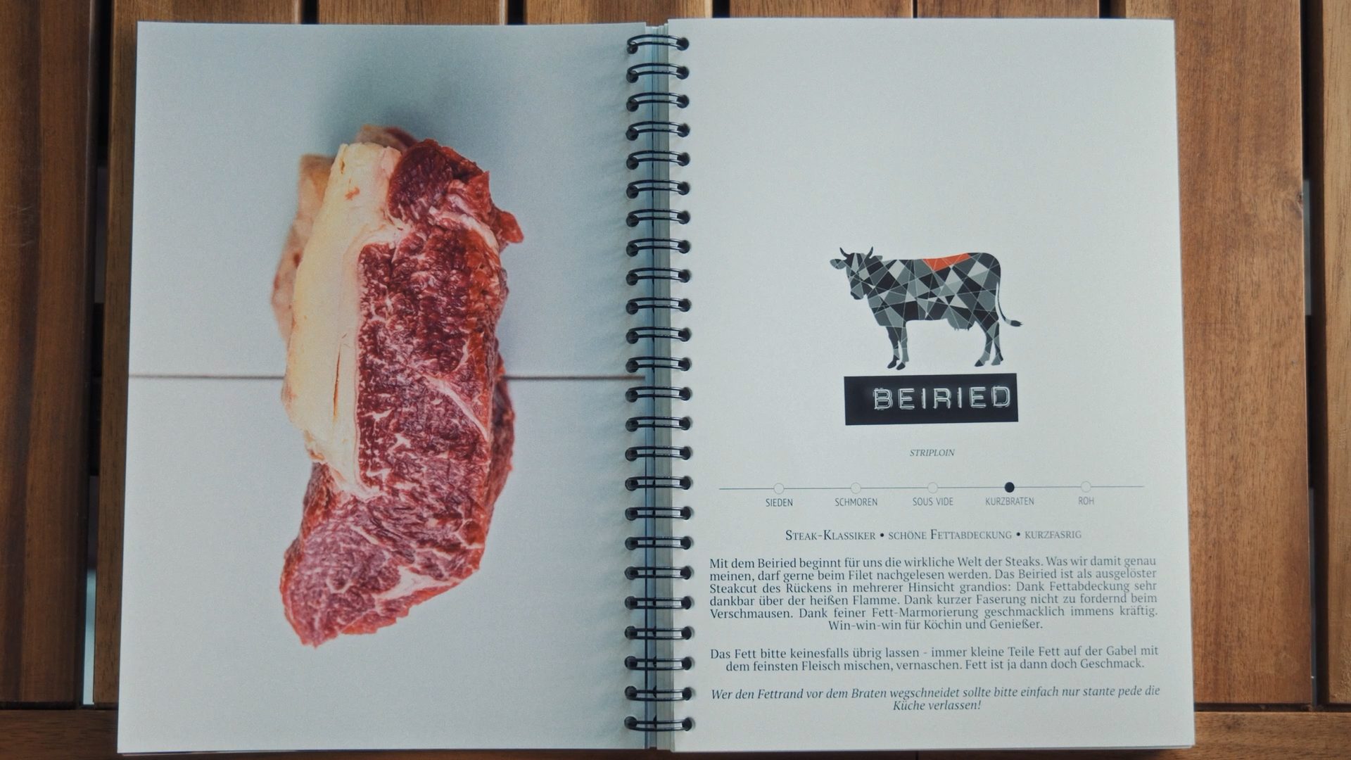 An open cookbook featuring a raw striploin steak on one page and information about "Beiried" (striploin) with a cow diagram on the other.
