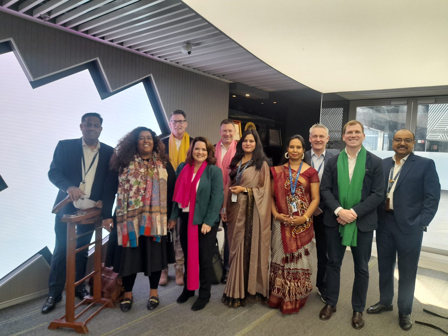 Interior design, Social group, Formal wear, Suit trousers, Smile, Standing, Coat, Dress