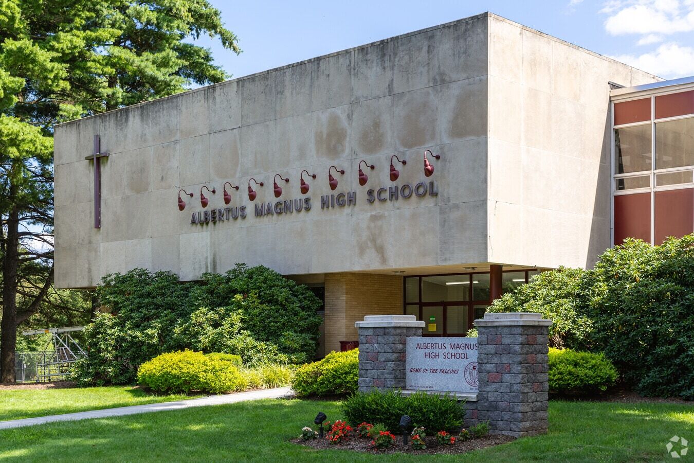 Albertus Magnus High School building exterior with its name on the facade and a welcome sign.