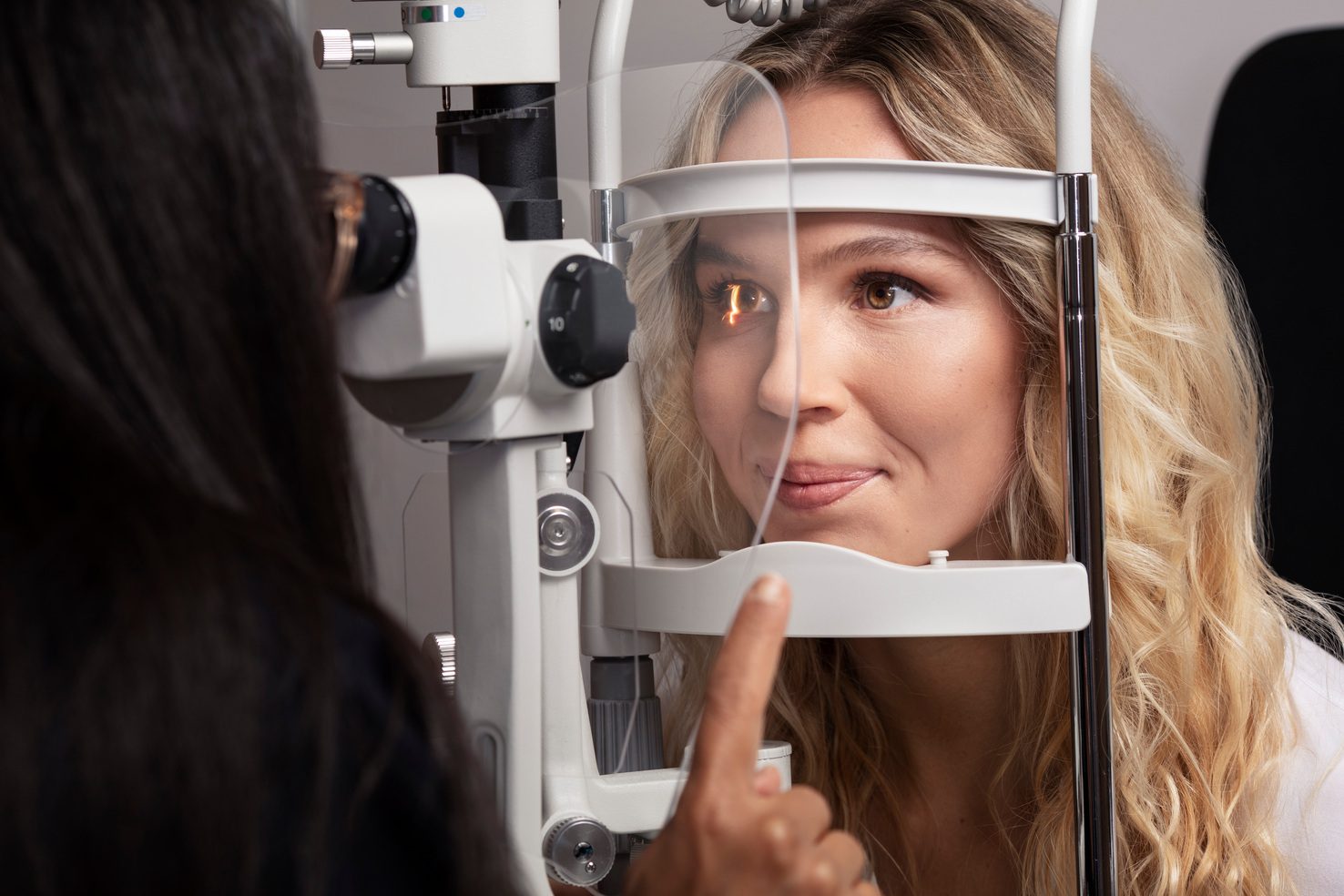 Patient having an eye exam with a slit lamp machine.