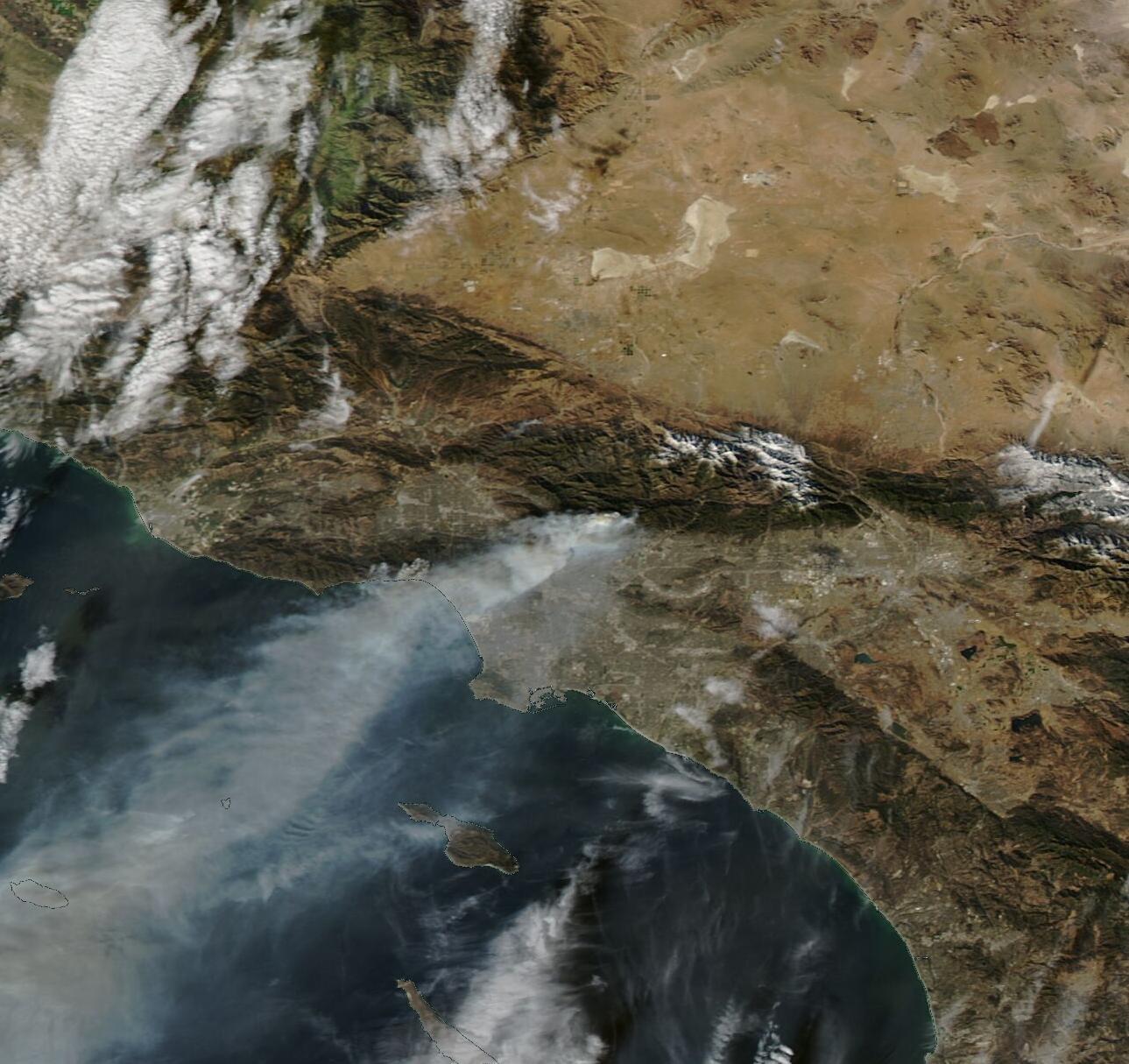 Satellite image of California coast, mountains, and land with large wildfire smoke plume.
