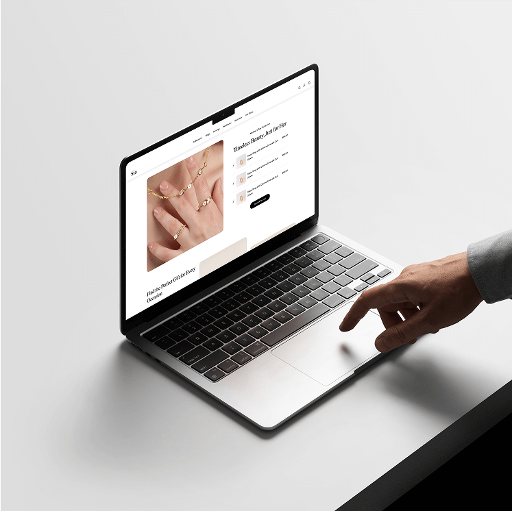 Person's hand interacting with a laptop displaying an online jewelry store.