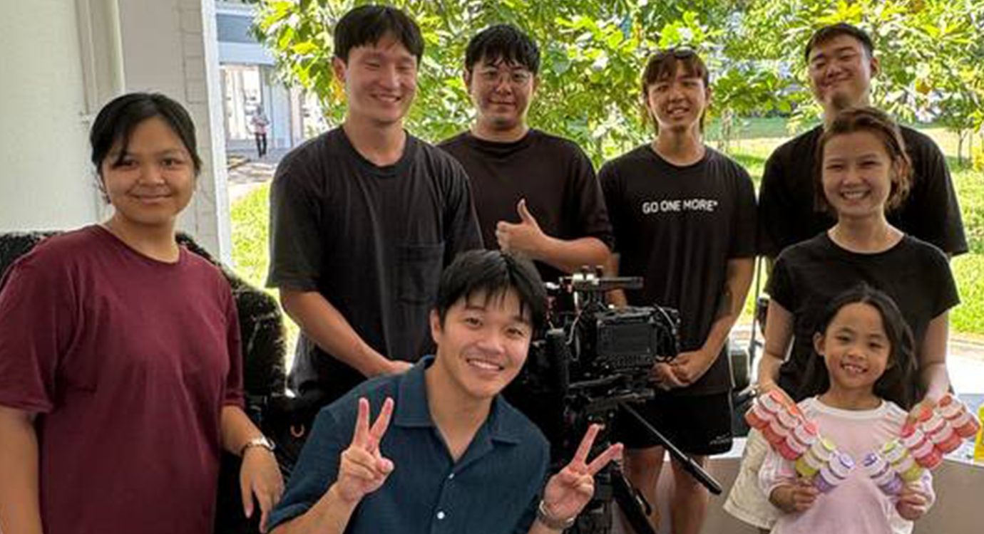 Film crew and child smiling with camera equipment.