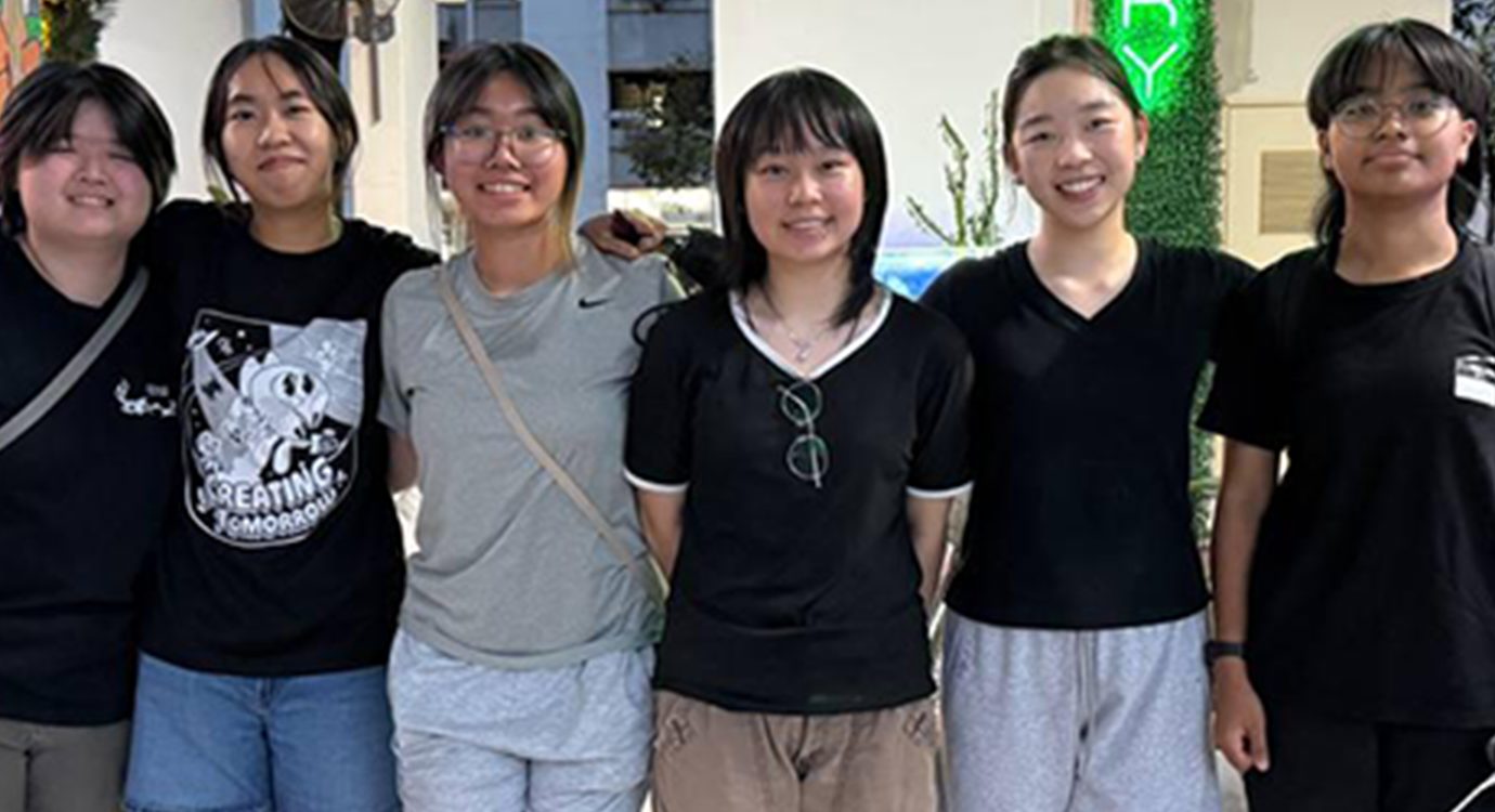 Six smiling women posing for a group photo.