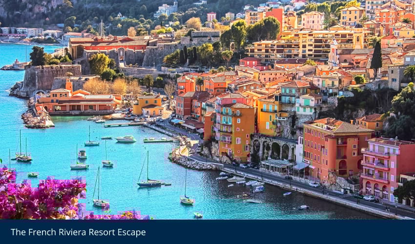 Colorful French Riviera town with a bay full of boats and buildings clinging to hills.