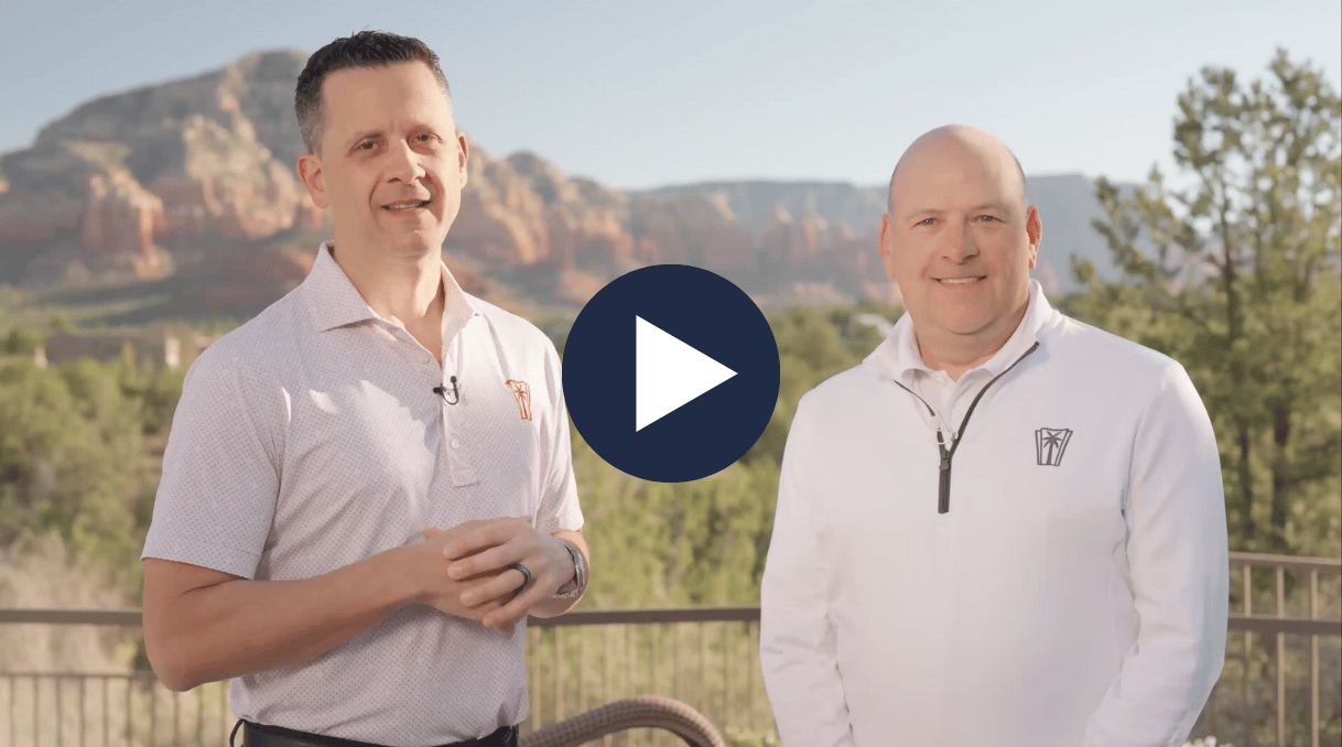 Two smiling men outdoors with red rock mountains and a play button overlay.