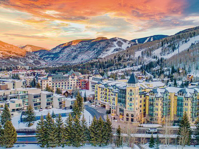 Ski resort in snowy mountain valley at sunset.