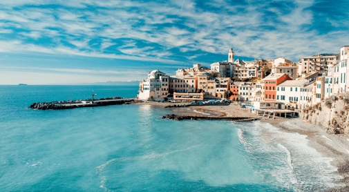 Coastal town with colorful buildings, a pier, and a pebble beach by vibrant turquoise sea under a blue sky.
