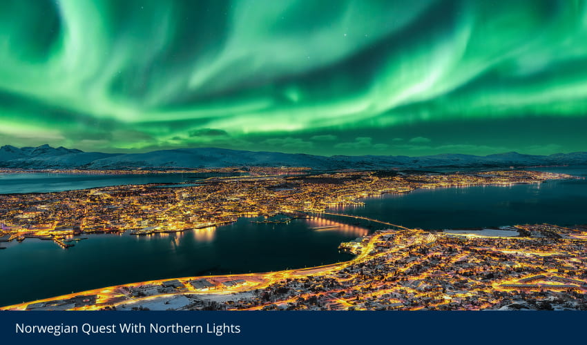 Vivid green Northern Lights illuminate a city at night by a bay and mountains.