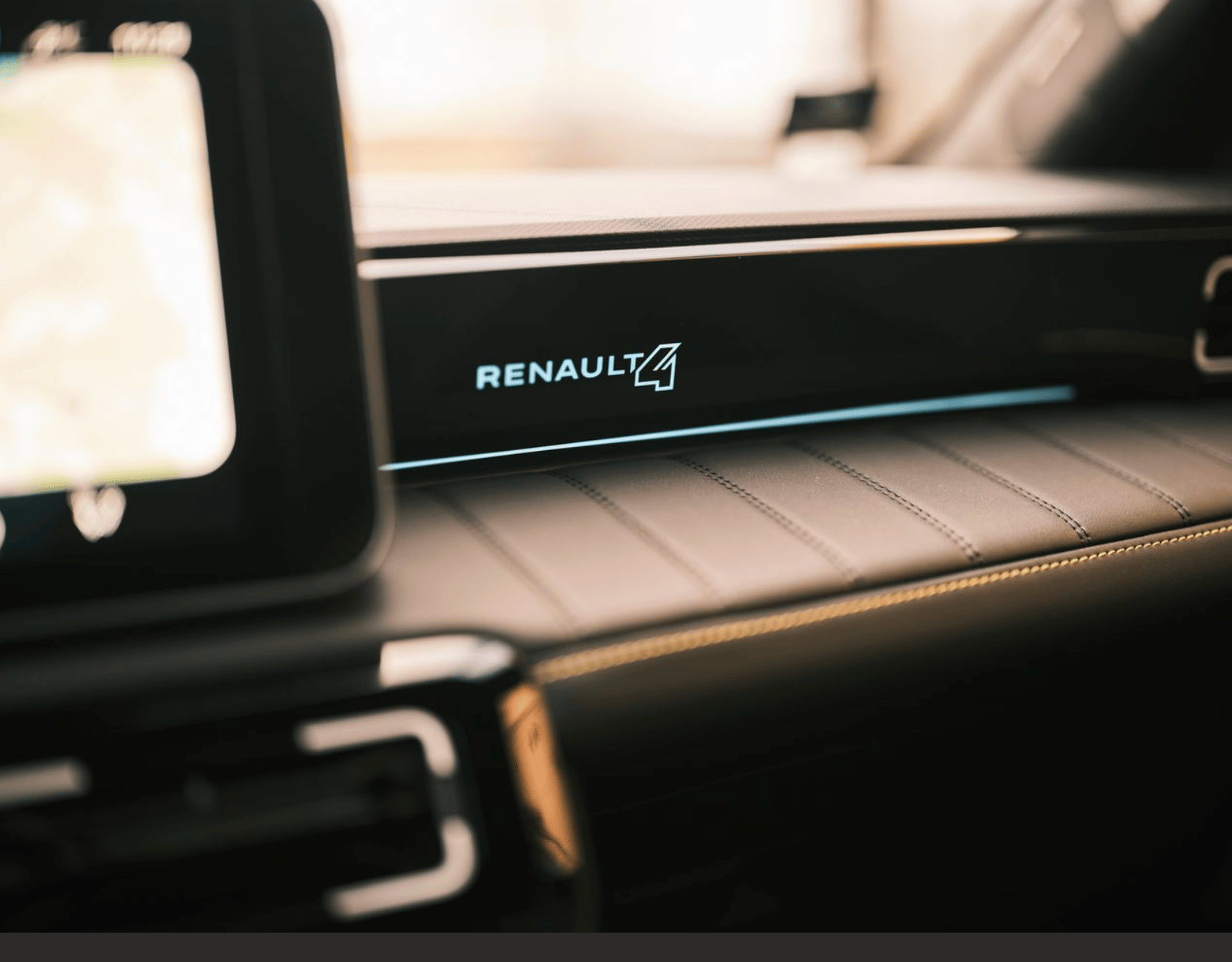 Car interior with "RENAULT 4" logo illuminated on a black dashboard strip above stitched leather.