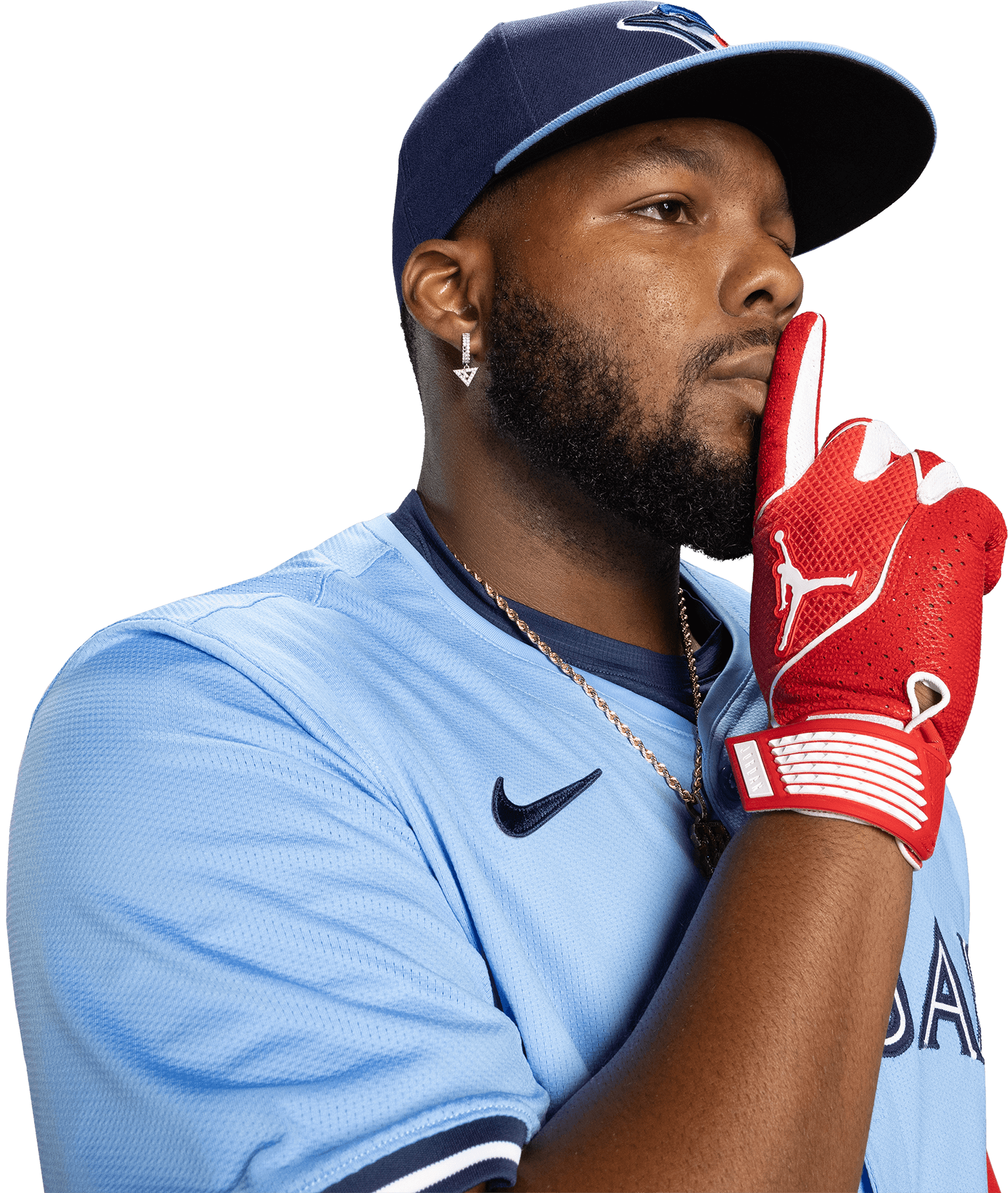 A baseball player in a blue jersey and red glove makes a 'shhh' gesture with his finger on his lips.