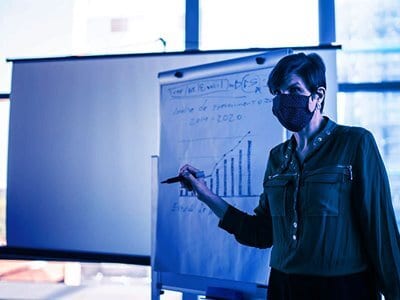 A man presenting graphs and data on whiteboard