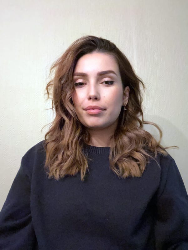 Woman with wavy brown hair in a dark sweater.