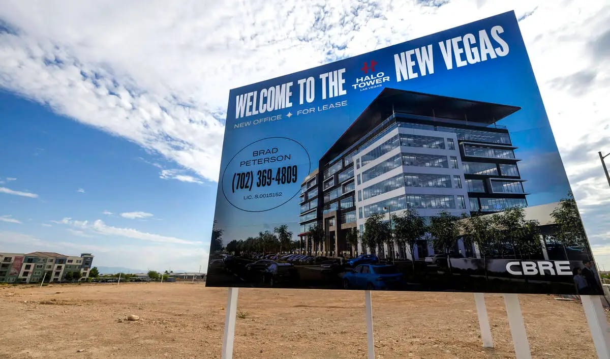 Large billboard advertises "Halo Tower New Vegas" office space for lease on a dirt lot.
