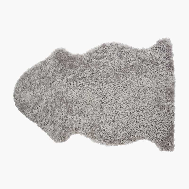 Irregularly shaped light grey shaggy rug.