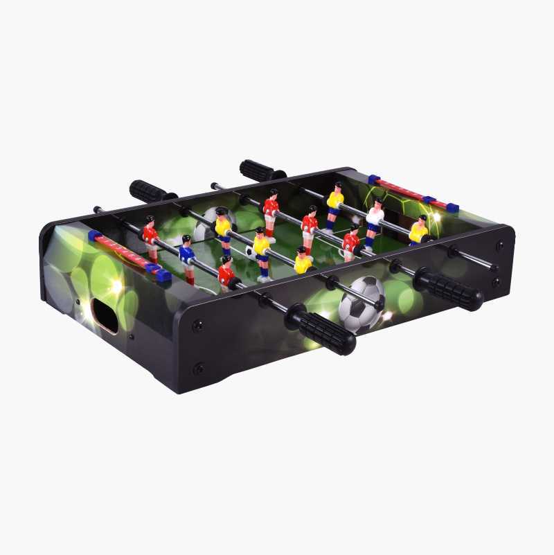 A miniature foosball table with red and yellow players on a green field and a football.